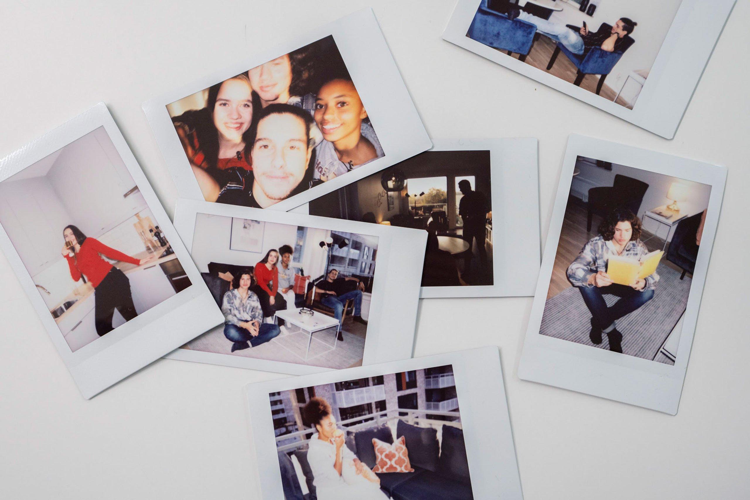Mange polaroidbilder lagt ut på et hvitt bord