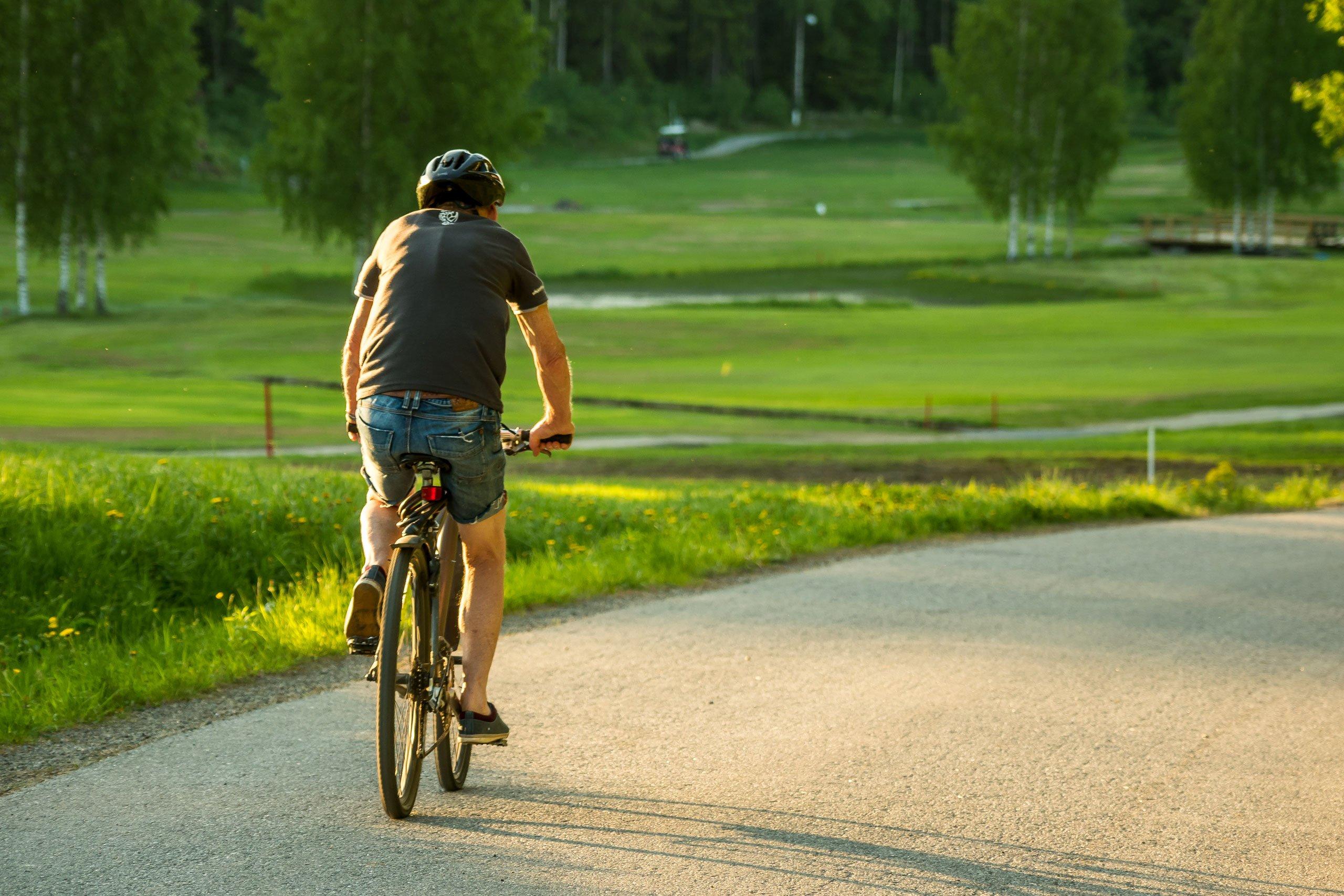 Mann som sykler i den fine naturen rundt de nye JM boligene i Oppegård