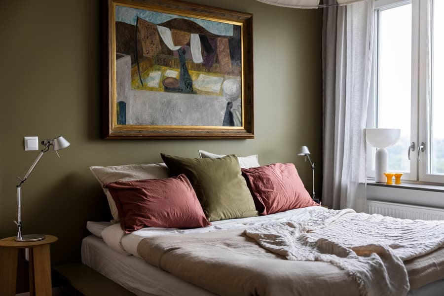 Sovrumsinredning. Brungröna väggar och detaljer i brunt, grönt och röda nyanser.