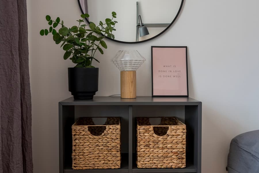 Sovrumsmöbler. Svart byrå med bruna korgar.